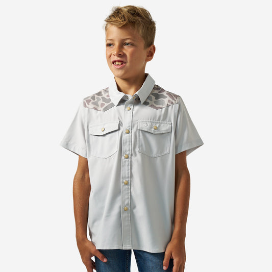 Boy wearing the Bird SZN Youth Performance Western Shirt, light grey with Classic Deer Camo yokes, front view