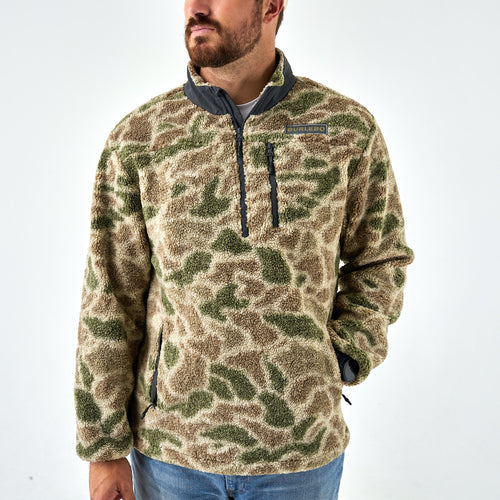 Camouflage pullover worn by a person on a white background