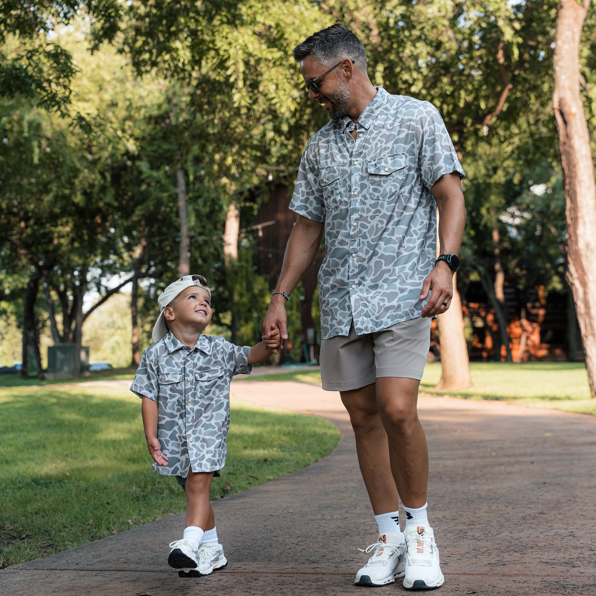 Man and child walking together on a path in a park
