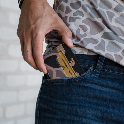 Person inserting a camouflage-patterned card into their pocket