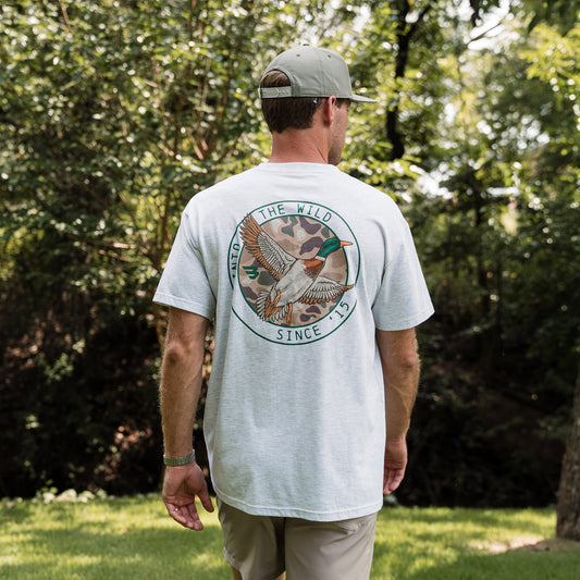 Man wearing a white t-shirt with a nature-themed design outdoors