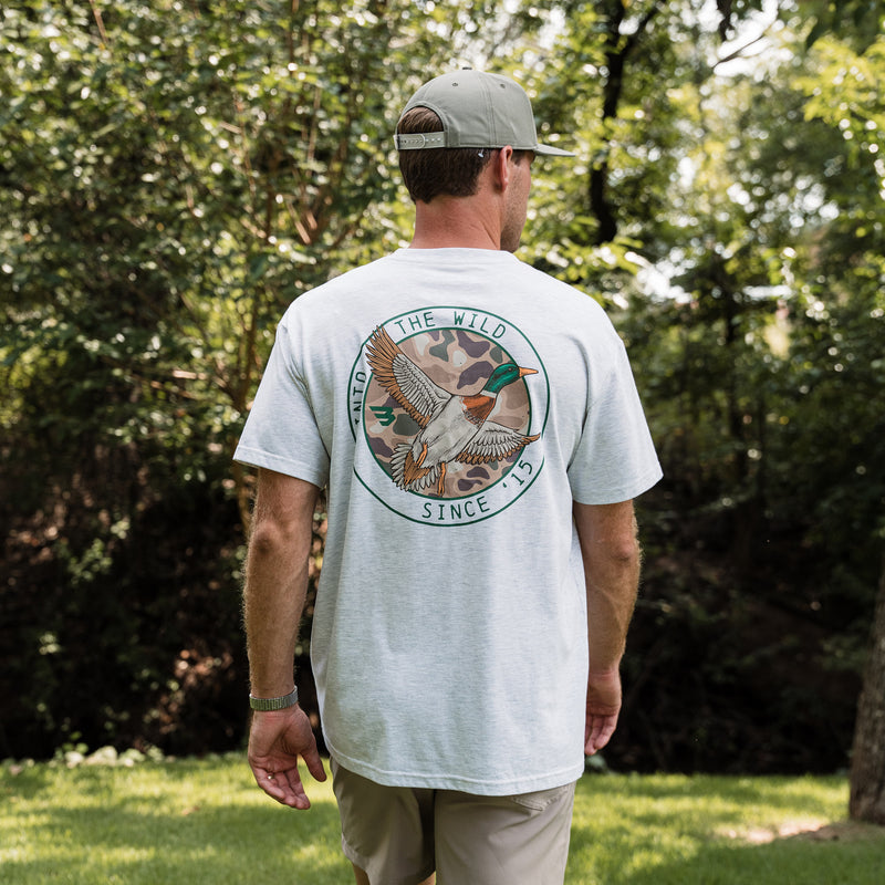 Man wearing a white t-shirt with a nature-themed design outdoors