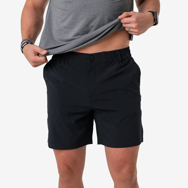Man lifting his gray tee to show the waistband of the Matte Black Everyday Short with Retro Duck Camo Pocket
