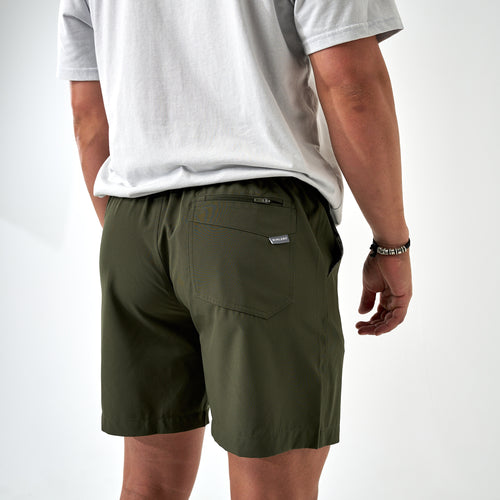 Person wearing green shorts and a white shirt on a white background