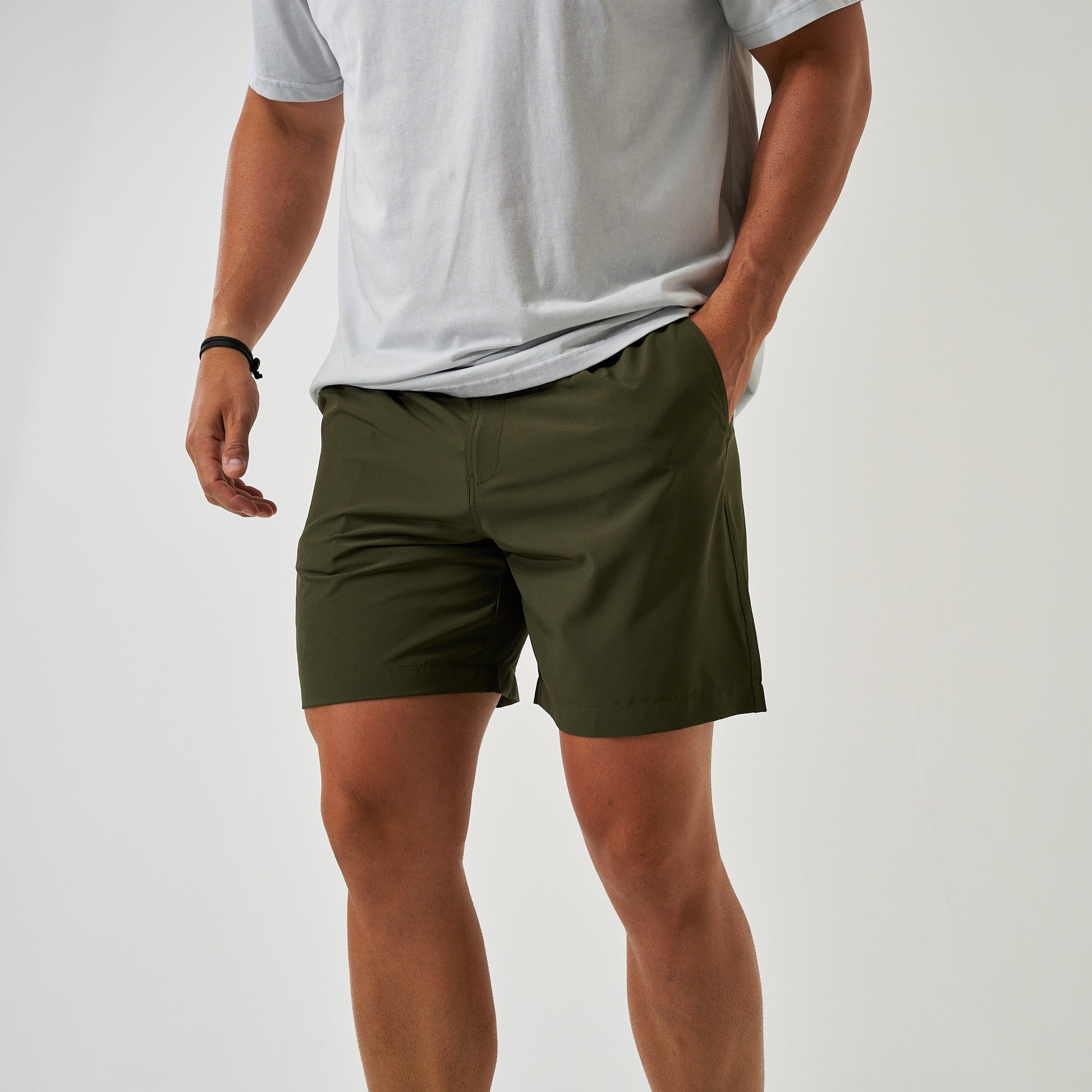 Person wearing olive green shorts and a light gray t-shirt on a plain background