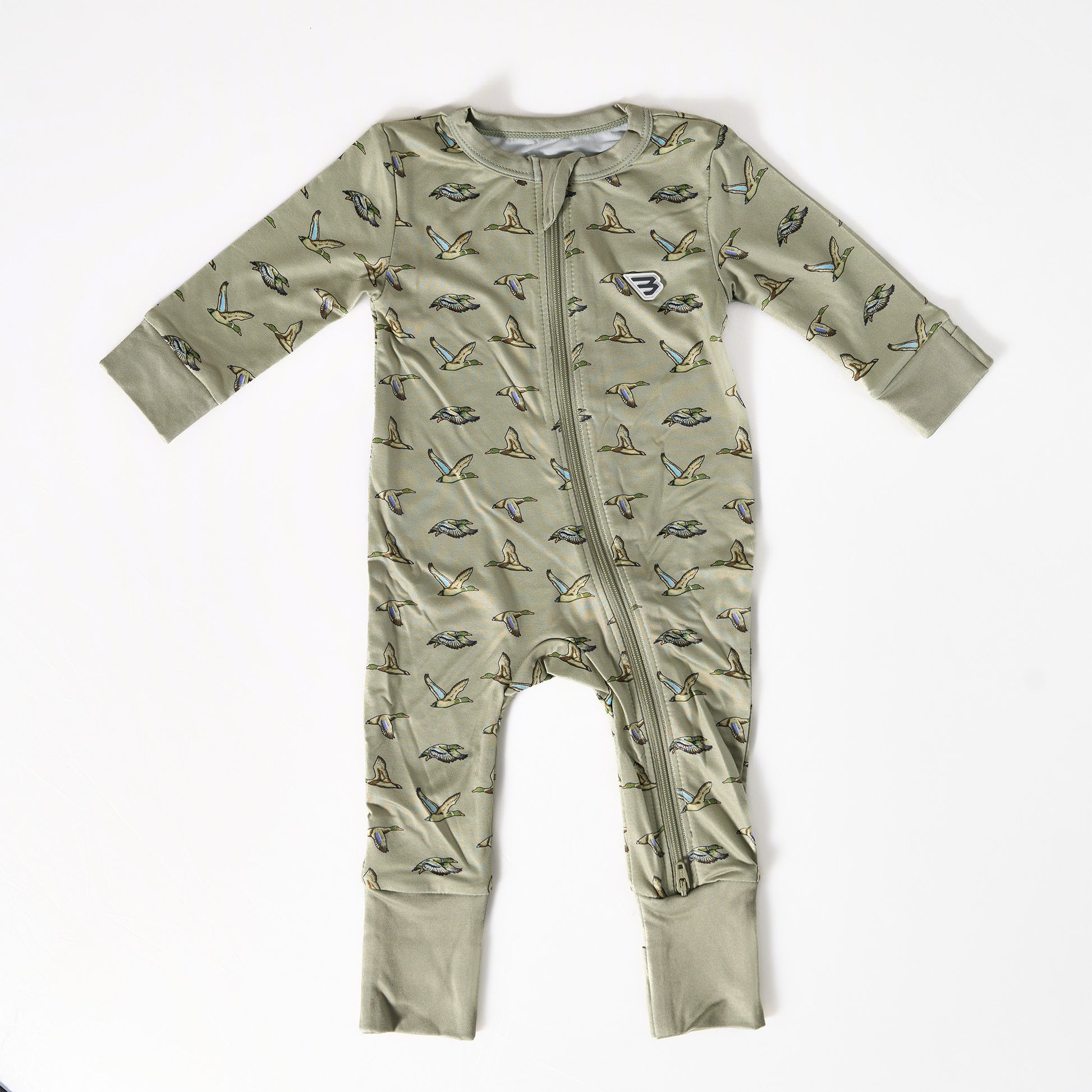 Green baby onesie with bird pattern on a white background