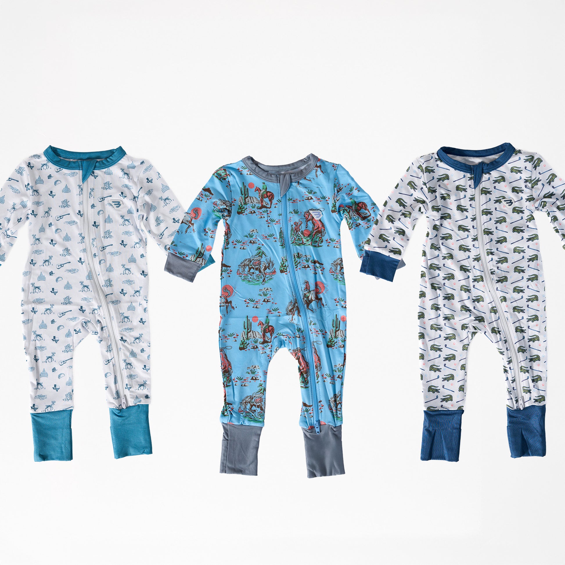 Three baby zip ups with different patterns on a white background