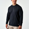 Smiling man wearing the Black Long Sleeve Go To Tee with khaki pants, front view on a white background