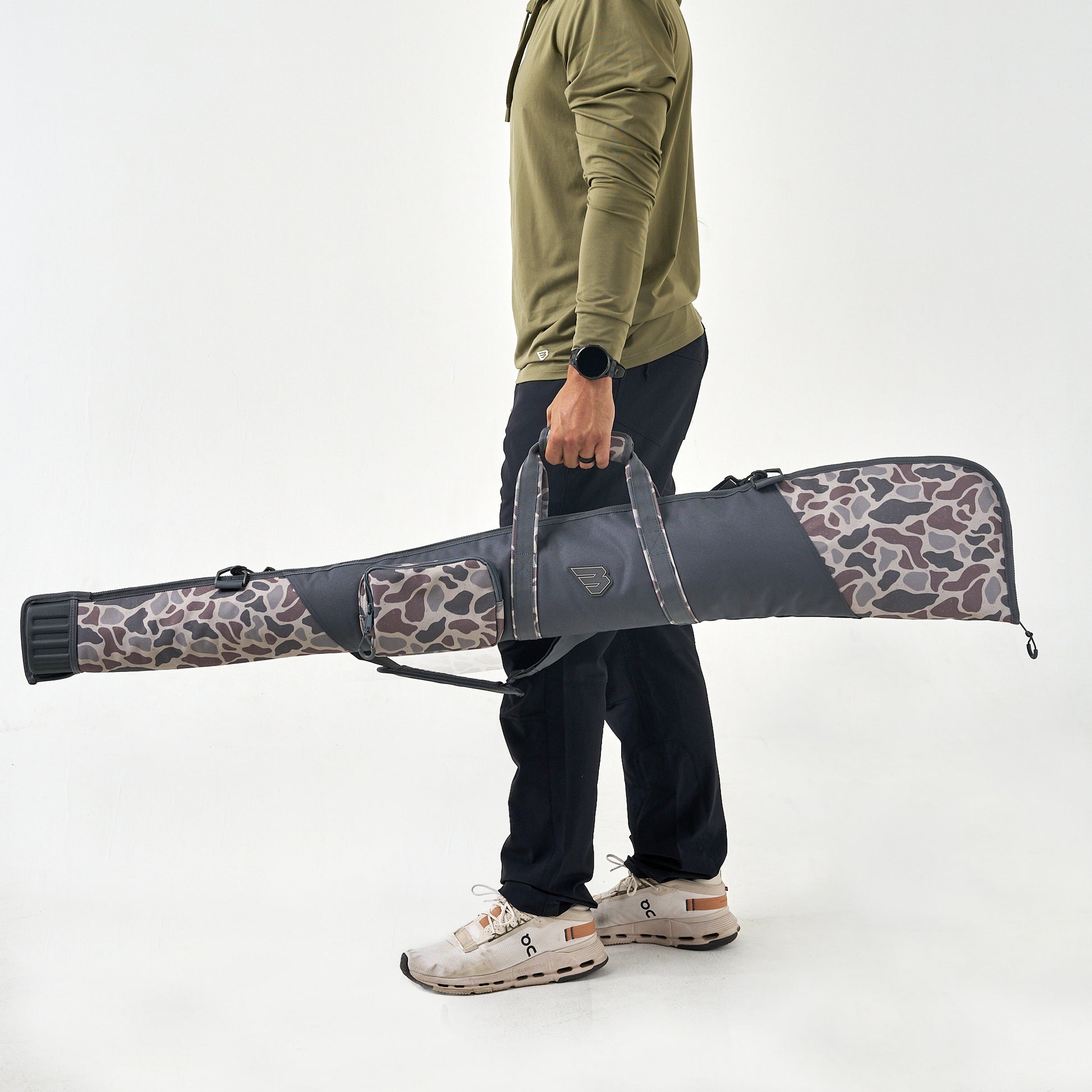 Person holding a large bow case with a camouflage pattern on a white background