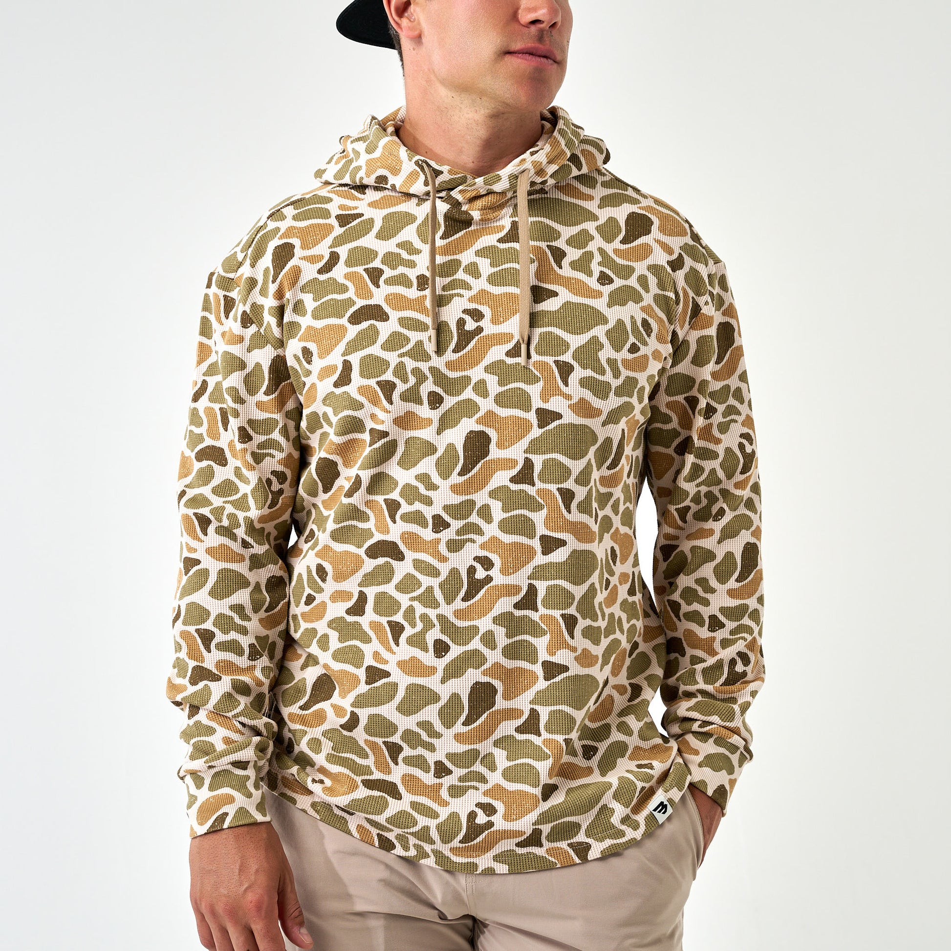 Person wearing a camouflage hoodie on a white background