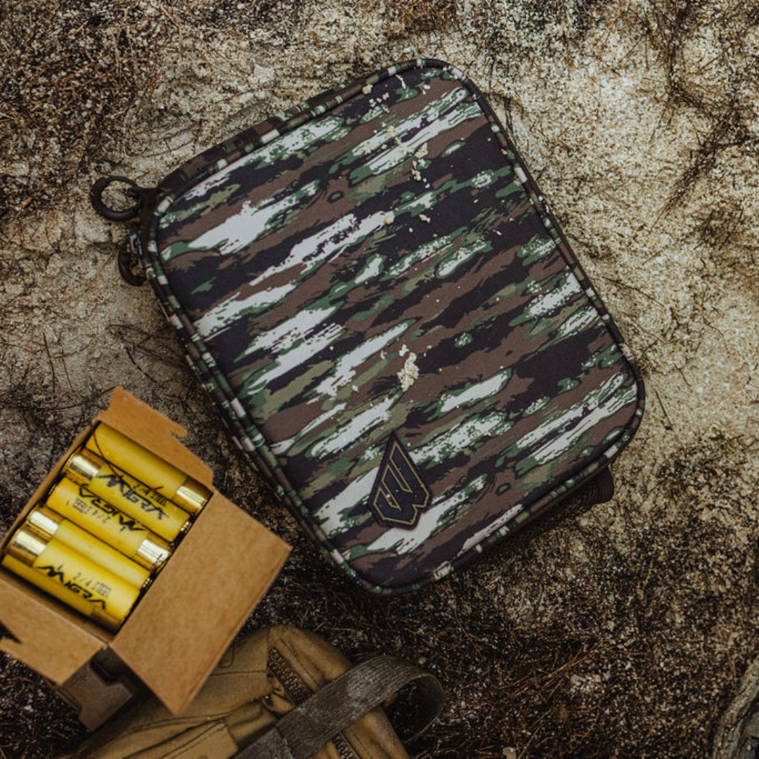 Camouflage pouch with a box of yellow cartridges on a textured surface