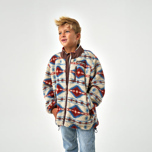 Child wearing a patterned jacket on a white background