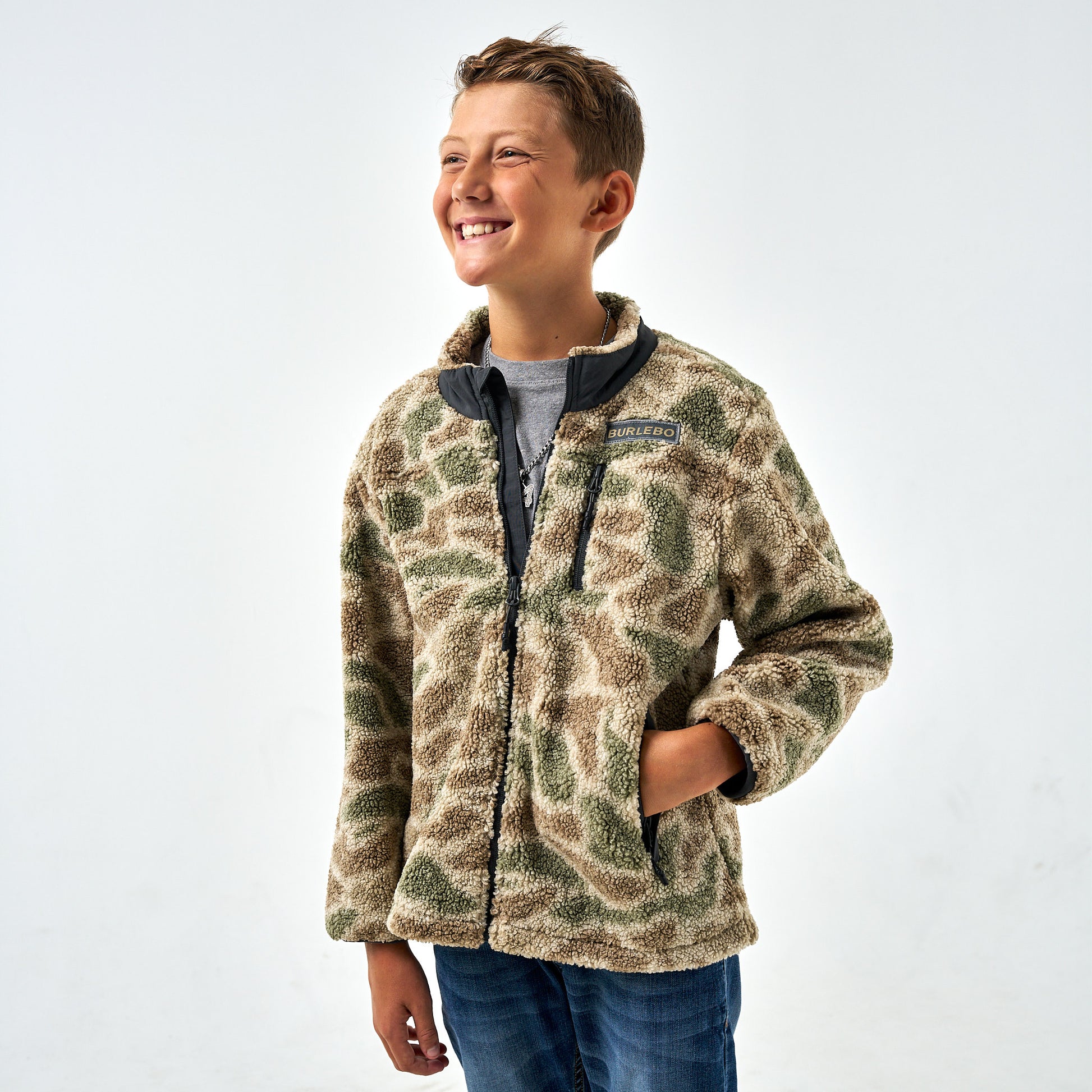 Child wearing a camouflage jacket on a white background